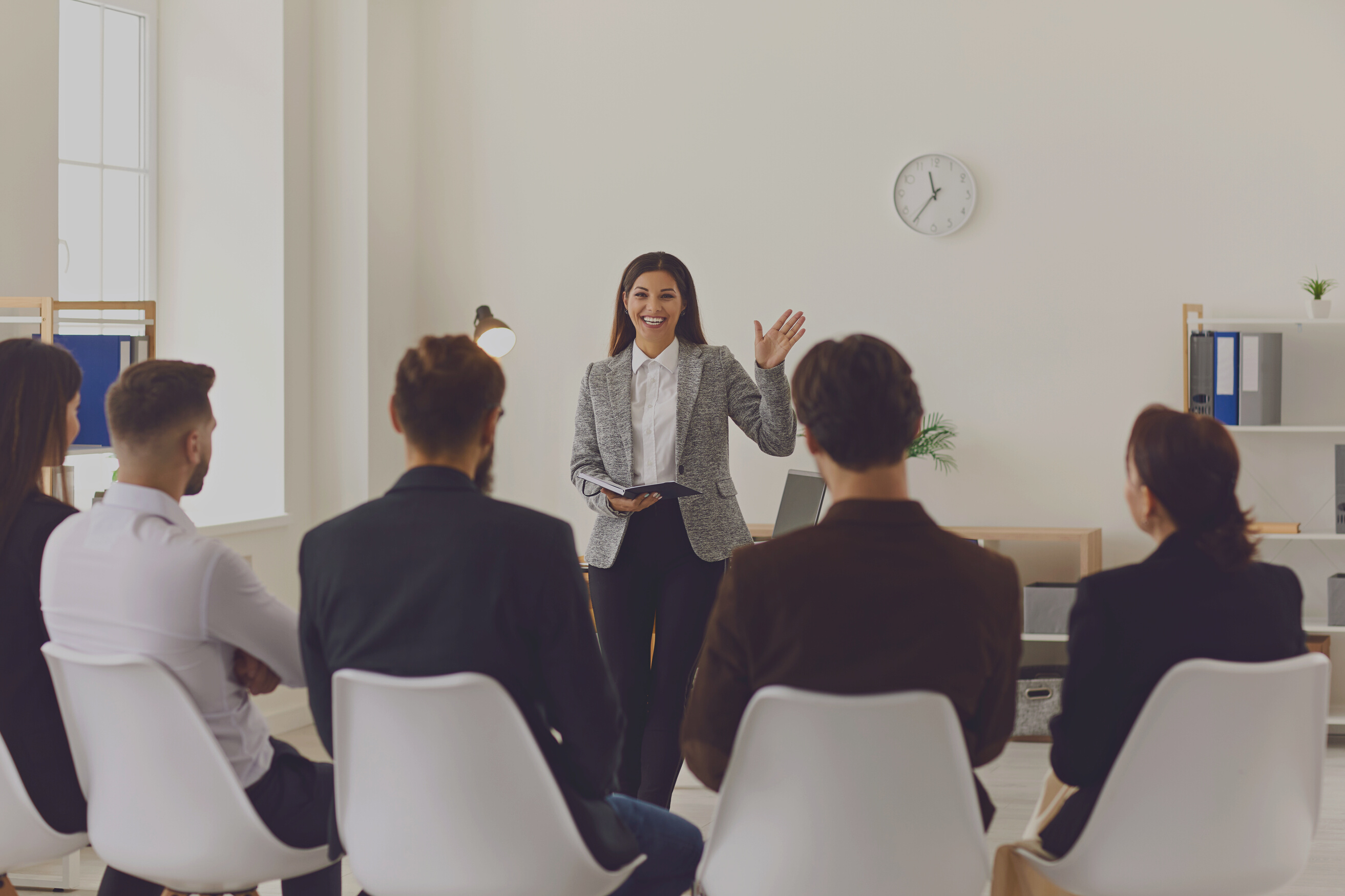 Smiling Company Manager or Team Leader Greeting Workers or Interns in Corporate Meeting