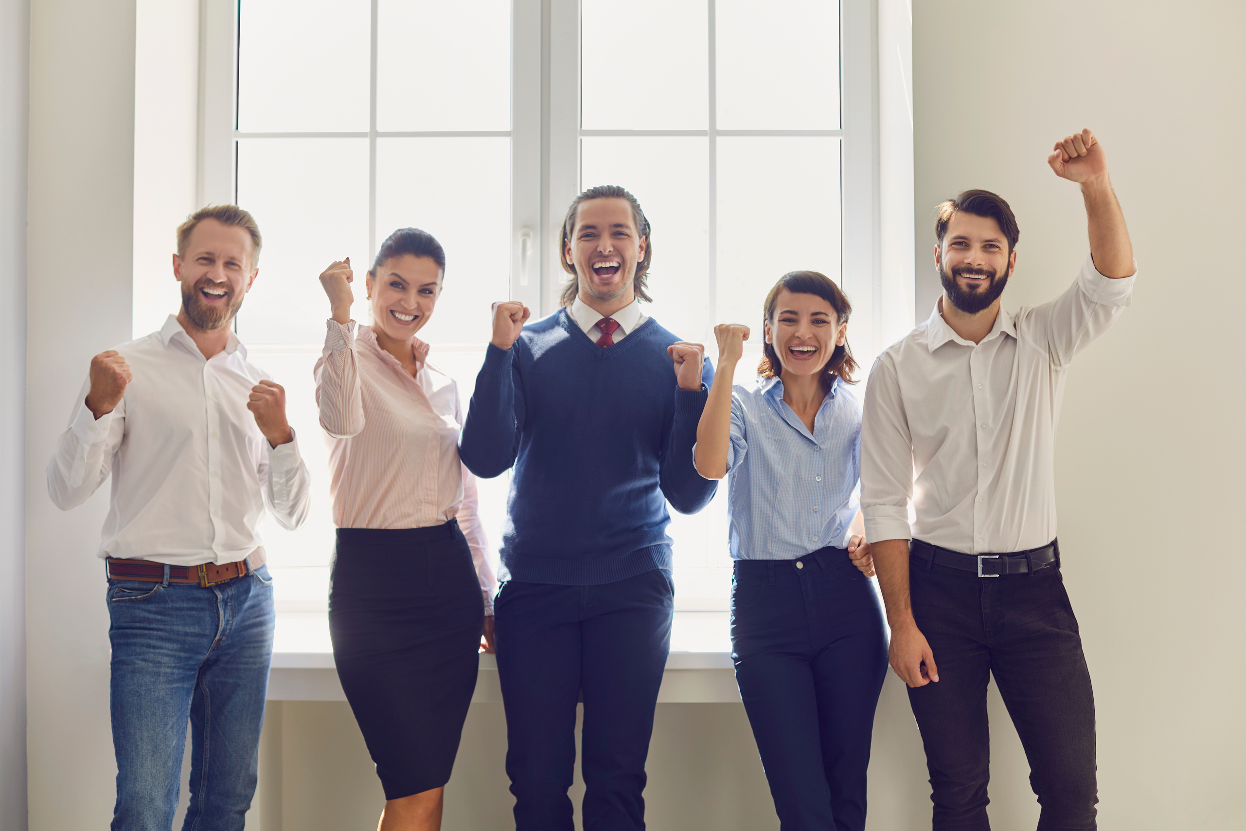 Group of Smiling Business People Expressing Successful Teamwork or Project Realization in Office
